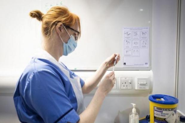 An NHS nurse prepares a dose of a Covid-19 vaccine