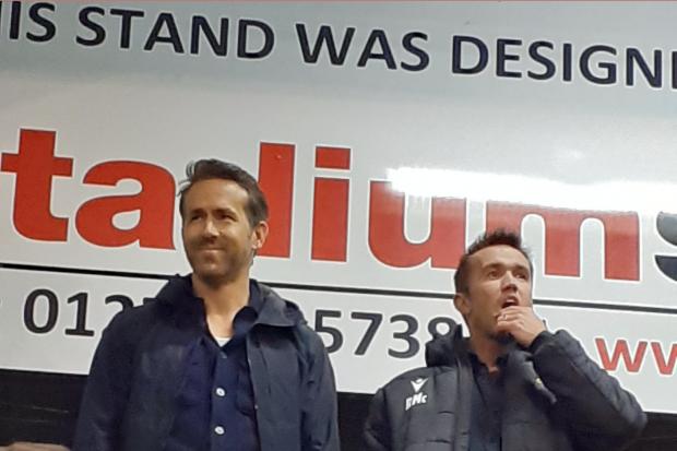 Handout photo taken with permission from the twitter feed of @tristanswalk showing Wrexham AFC owners Ryan Reynolds (left) and Rob McElhenney during the Vanarama National League game at York Road, Maidenhead. Picture date: Tuesday October 26, 2021.