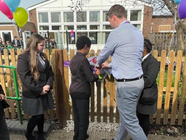 Slough Observer: Heateacher Tom Brunson and students cutting the ribbon to mark the opening of the new sensory garden. Picture: Slough Observer