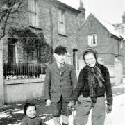 Ron, his sister Brenda and their cousin in the snow in Hencroft Street, Slough. The building with the chimneys in the background was the local school